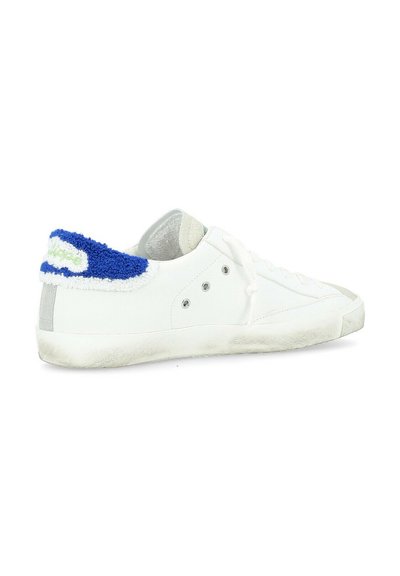 Sneaker bianca con un colletto in pelliccia texture blu e verde, punta tonda e occhielli in argento. Leggermente usata con una suola in gomma testurizzata.