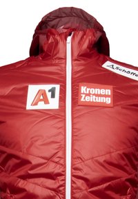 Rote isolierte Jacke mit hohem Kragen, Frontreißverschluss und Logos auf der Brust. Verfügt über ein gestepptes Muster mit glatter Textur. Weißer Reißverschluss.