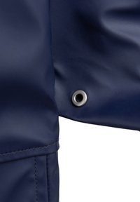 Navy veden vesotěsný materiál má na levé straně kovový patent, hladký povrch a čisté švy v kompaktním designu.