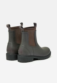 Ciemnoszare botki za kostkę wykonane z gumy, z brązowym elastycznym bocznym panelem i uchwytami. Gumowa podeszwa z bieżnikiem dla lepszej przyczepności.