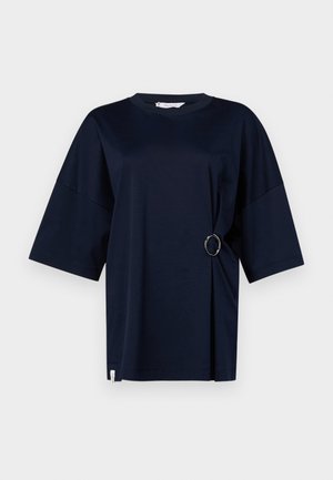 Navyblaues T-Shirt mit kurzen Ärmeln und rundem Halsausschnitt, das einen silbernen Ringakzent an der Taille und einen seitlichen Schlitz aufweist. Weicher Stoff.