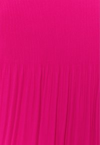 Fuchsia klänning med vertikal ribbad textur, med veck vid midjan som skapar en flödande silhuett. Mjuk, stretchig material.