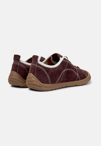 Chaussures en daim marron avec des coutures et des lacets blancs, montrant une vue de côté avec une semelle en caoutchouc texturée. Convient pour un port décontracté.