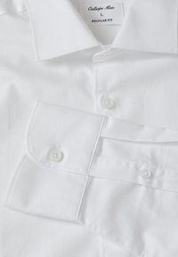 Camicia bianca con vestibilità regolare, tessuto strutturato con un sottile motivo a righe e chiusure a bottone bianche sui polsini e sul colletto.