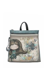 Bolsa verde y beige con una ilustración de una niña de dibujos animados, cierre de cremallera y asas negras, con acentos decorativos y el texto "Sueños Desplegados".