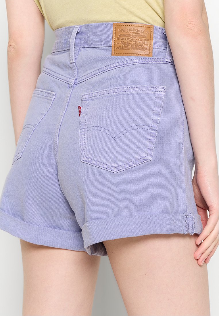 Lavender jeans high-waisted shorts met opgerolde mouwen, voorzien van twee achterzakken en een bruine leren merketiket op de tailleband.