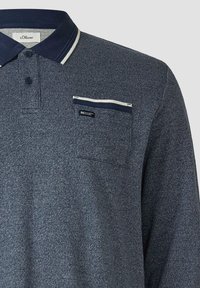 Marineblaues, strukturiertes Polohemd mit langen Ärmeln, dunkelblauem Kragen, zwei Knöpfen und einer Brusttasche mit weißem und marineblauem Besatz.