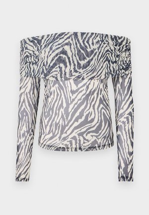 Off-shoulder langermet topp laget av gjennomsiktig stoff med et svart-hvitt zebra mønster og rynkedetaljer ved utringningen.