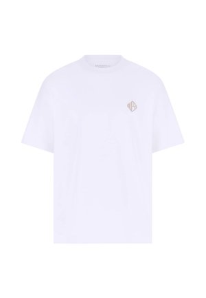 Bijela pamučna majica opuštenog kroja s malim bež grbom na lijevoj strani prsa. Kratki rukavi i okrugli izrez na vratu.