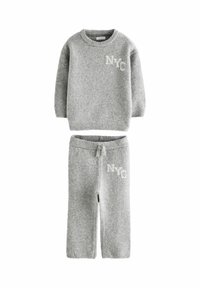 Completo in maglia grigia composto da maglione e pantaloni con polsini a coste, scollo rotondo e "NYC" ricamato in grigio chiaro su entrambi i capi.