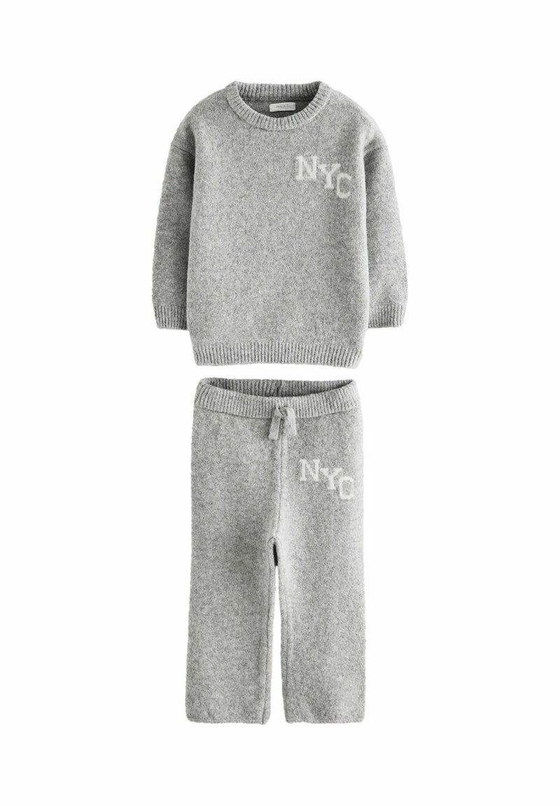 Completo in maglia grigia composto da maglione e pantaloni con polsini a coste, scollo rotondo e "NYC" ricamato in grigio chiaro su entrambi i capi.