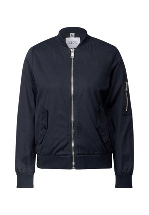 Námořnická modrá bomber bunda se zipem v přední části, žebrovanými manžetami a dvěma bočními kapsami; má malou zipovou kapsu na levém rukávu.