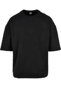 Černý oversized svetr s krátkými rukávy, vyrobený z měkké tkaniny. Má kulatý výstřih a lem, který končí těsně pod pasem.