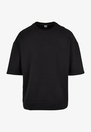 Černý oversized svetr s krátkými rukávy, vyrobený z měkké tkaniny. Má kulatý výstřih a lem, který končí těsně pod pasem.