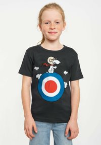 Black t-shirt featuring Snoopy in goggles and a red scarf, standing on a roundel design with blue, red, and white accents; short sleeves.