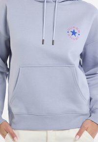 Felpa leggera blu chiaro in misto cotone, con tasca frontale, coulisse e un design del logo con una stella e testo sul petto.