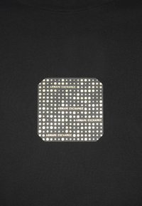 T-shirt preta com um logótipo quadrado de design texturizado, apresentando pontos brancos e o texto "ARMANI EXCHANGE" num padrão repetido.