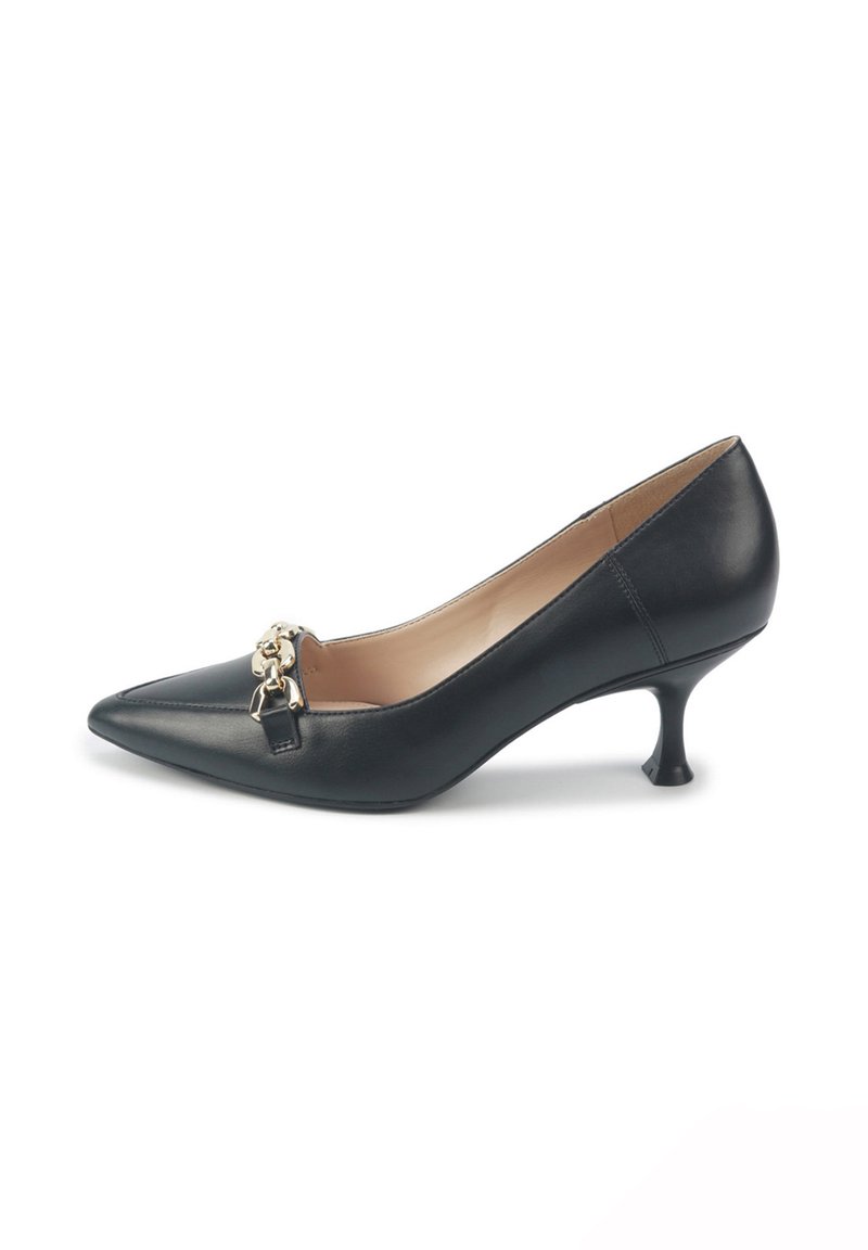 Zapato de tacón alto de cuero negro con punta afilada, que presenta un acento de cadena dorada en la parte delantera y un diseño de tacón curvado y estrecho.