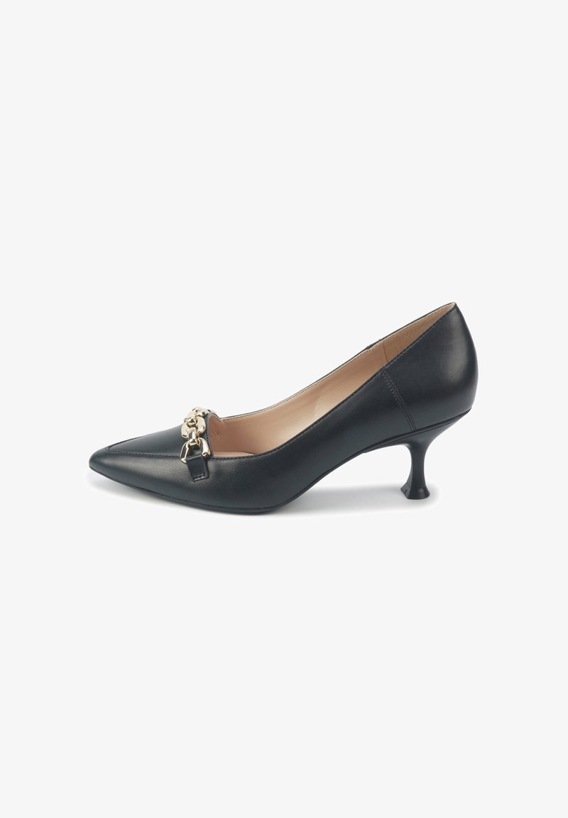 Zapato de tacón alto de cuero negro con punta afilada, que presenta un acento de cadena dorada en la parte delantera y un diseño de tacón curvado y estrecho.