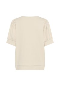 Top corto a maniche corte di un beige chiaro realizzato in tessuto morbido. Caratterizzato da una vestibilità consona, maniche arrotolate e un semplice scollo a barca senza marchi visibili.