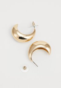 Gold crescent-shaped earrings with a smooth, shiny surface. Includes a metal post and clear backing for secure wearing.