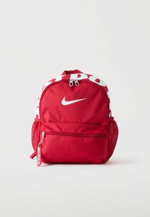 Κόκκινο σακίδιο Nike με λευκό λογότυπο Swoosh, διπλούς φερμουάρ, μπροστινό τσεπάκι με φερμουάρ, δίχτυα πλαϊνών τσεπών και λευκό κείμενο στην πάνω άκρη.
