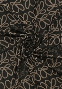 Czarny materiał z powtarzającym się florystycznym wzorem w metalicznej złotej barwie, charakteryzujący się miękką teksturą oraz płynnością formy, z misternymi detalami.