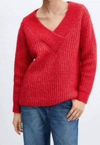 Pull en tricot rouge avec un décolleté en V profond et des manches trois-quarts, présentant un motif texturé et une coupe décontractée. Assorti à un jean bleu.