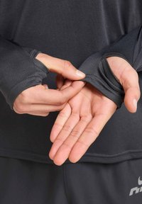 Langärmeliges Sportshirt aus dunkelgrauem Stoff mit Daumenlöchern in den Bündchen; Nahaufnahme von Händen, die den Ärmel justieren.