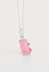 Rosa gummibjörns-hänge med en frostad yta, hängande från en silverkedja med en detaljerad låsning och pärlaccentuerade detaljer.