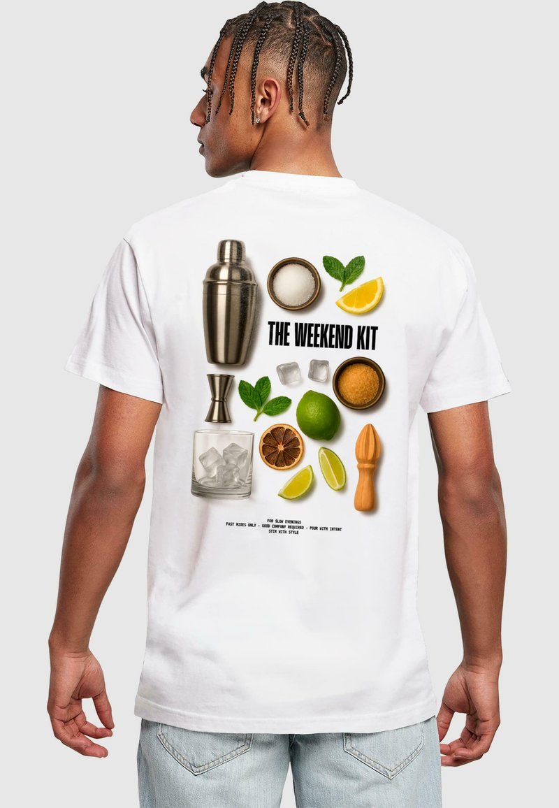 Bílý tričko s grafikou náčiní na koktejly, čerstvého ovoce a barových nástrojů. Text zní "THE WEEKEND KIT" tučnými černými písmeny.