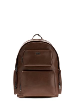 Sac à dos en cuir marron avec une forme arrondie. Il dispose d'une poignée supérieure, de plusieurs poches zippées et d'une texture lisse avec un branding subtil.