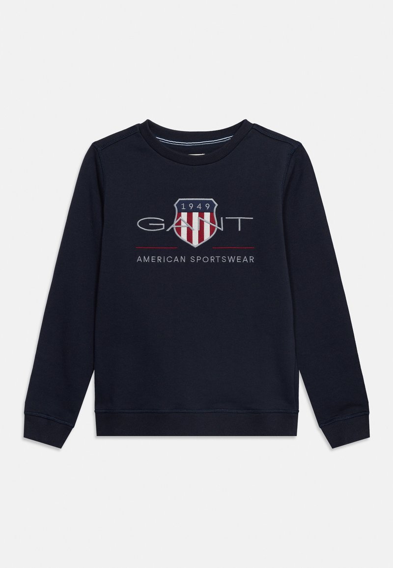 Μακρυμάνικο μπλούζα σε ναυτικό μπλε με το λογότυπο "GANT", κόκκινο και λευκό έμβλημα ασπίδας, το "1949" και το κείμενο "American Sportswear" στην μπροστινή πλευρά.