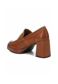 Zapato de tacón alto de cuero marrón con un tacón grueso y cuadrado, puntera redonda y correa decorativa con acentos metálicos. Textura suave.