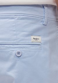 Ανοιχτό μπλε βαμβακερό σορτς με μπροστινή τσέπη, λευκή ραφή και τσέπη με καπάκι που διαθέτει ετικέτα "Pepe Jeans London" και κούμπωμα με κουμπί.