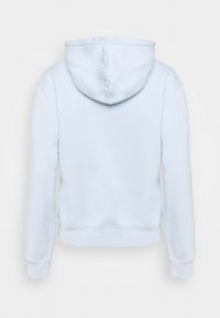 Vaaleansininen vetoketjuhuppari, jossa on ribbireunat ja hihansuut, pehmeä tekstuuri ja suuri, pyöreä hupun muoto. Etupuolella ei ole näkyviä yksityiskohtia.