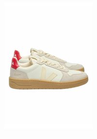 White leather sneakers with beige suede accents, tan rubber outsole, red heel tabs, and perforated toe box. Features logo on the heel.