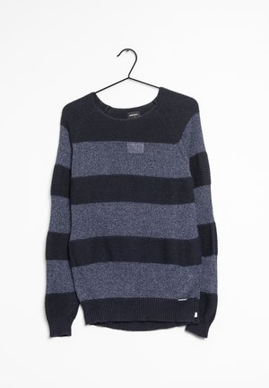 Pull en maille rayé bleu marine et gris à manches longues, suspendu sur un cintre en fil de fer noir sur fond blanc.