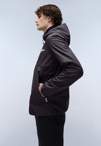 Czarna kurtka typu softshell z kapturem, posiadająca kieszeń na zamek i kieszenie boczne, gładka w dotyku, z minimalnym logo marki na klatce piersiowej.