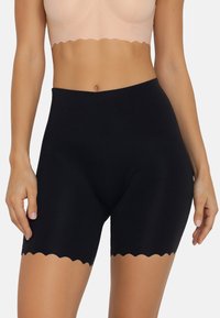 Fekete, magas derekú shorts sima anyagból, hullámos szegéllyel. A dizájn testhez simuló, a comb közepéig ér.