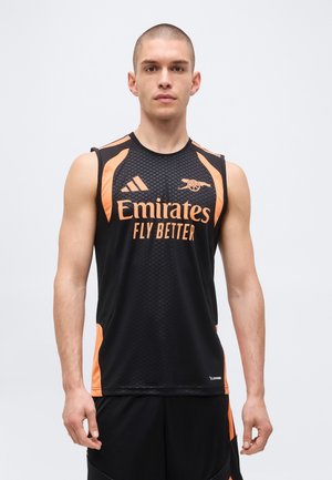 Ung mand iført sort og orange ærmeløs sportstrøje med "Emirates Fly Better" og Arsenal fodboldlogo.