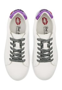 Baskets en cuir blanc avec des lacets mouchetés de noir et de gris. Accents violets sur le talon, ornés d'une empreinte de lèvres rouge sur la semelle intérieure.