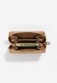 Bežová peňaženka so zipsom otvorená, ukazujúca viacero priehradiek, vrátane centrálneho zeleného zipsového vrecka na mince, priehradok na karty a názvu značky vo vnútri.
