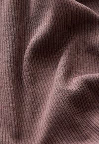 Tekstiilikangas pehmes lilas värvitoonis ribakujulise tekstuuriga, showing elastseid vertikaalseid mustreid ja õrnu voolavusi.