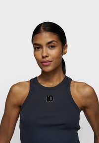 Marineblaue gerippte Tanktop mit hohem Ausschnitt, auf der Brust mit einer gestickten weißen Zahl "10" und breiten Trägern.