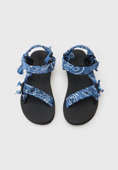 Μαύρα σανδάλια με σόλα και ρυθμιζόμενους μπλε υφασμάτινους ιμάντες με λευκά σχέδια πεϊσλεϊ και φθαρμένες άκρες, σε θέαση από ψηλά.
