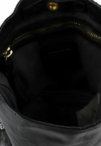 Interno di una borsa a tracolla nera in pelle con una texture liscia e opaca, cerniera dorata e un compartimento aderente con foderatura in tessuto scuro.