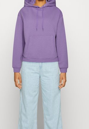 Haut à capuche violet en tissu doux, doté d'une poche avant, de cordons de serrage et de poignets côtelés, associé à un jean large en denim clair.