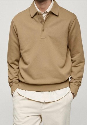 Pull-over sweat-shirt beige avec col, trois boutons, poignets et ourlet côtelés. Superposé sur une chemise claire à col.