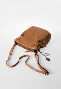 Borsa a mano in pelle marrone con una texture morbida, forma rettangolare, zip superiore e tracolla regolabile. Presenta un dettaglio a catena e un'etichetta rotonda.